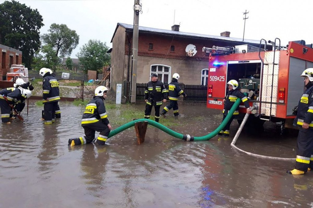 Zalane posesje, powalone drzewa, wyrwa w drodze