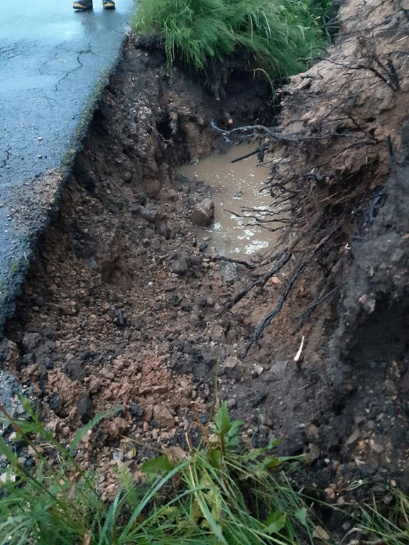 Zalane posesje, powalone drzewa, wyrwa w drodze