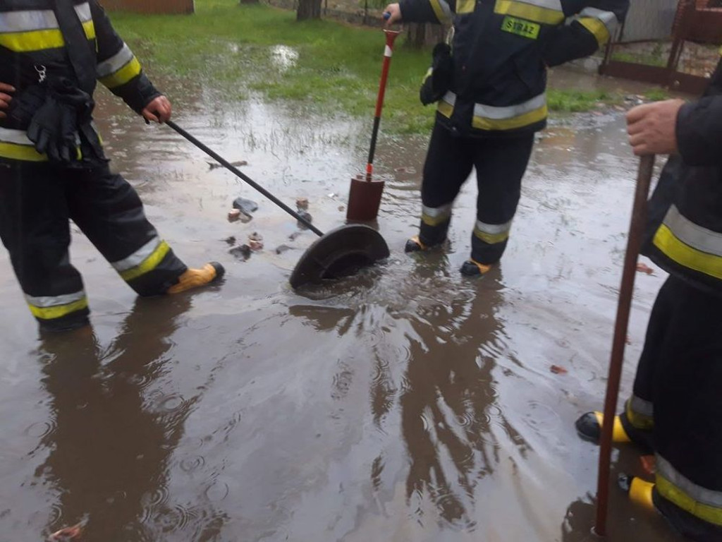 Zalane posesje, powalone drzewa, wyrwa w drodze