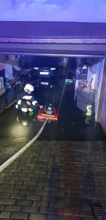 Zalane posesje, powalone drzewa, wyrwa w drodze