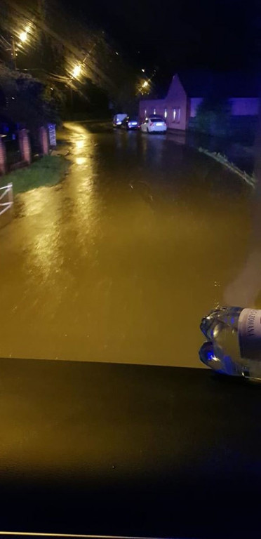 Zalane posesje, powalone drzewa, wyrwa w drodze