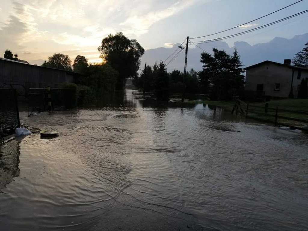 Zalane posesje, powalone drzewa, wyrwa w drodze