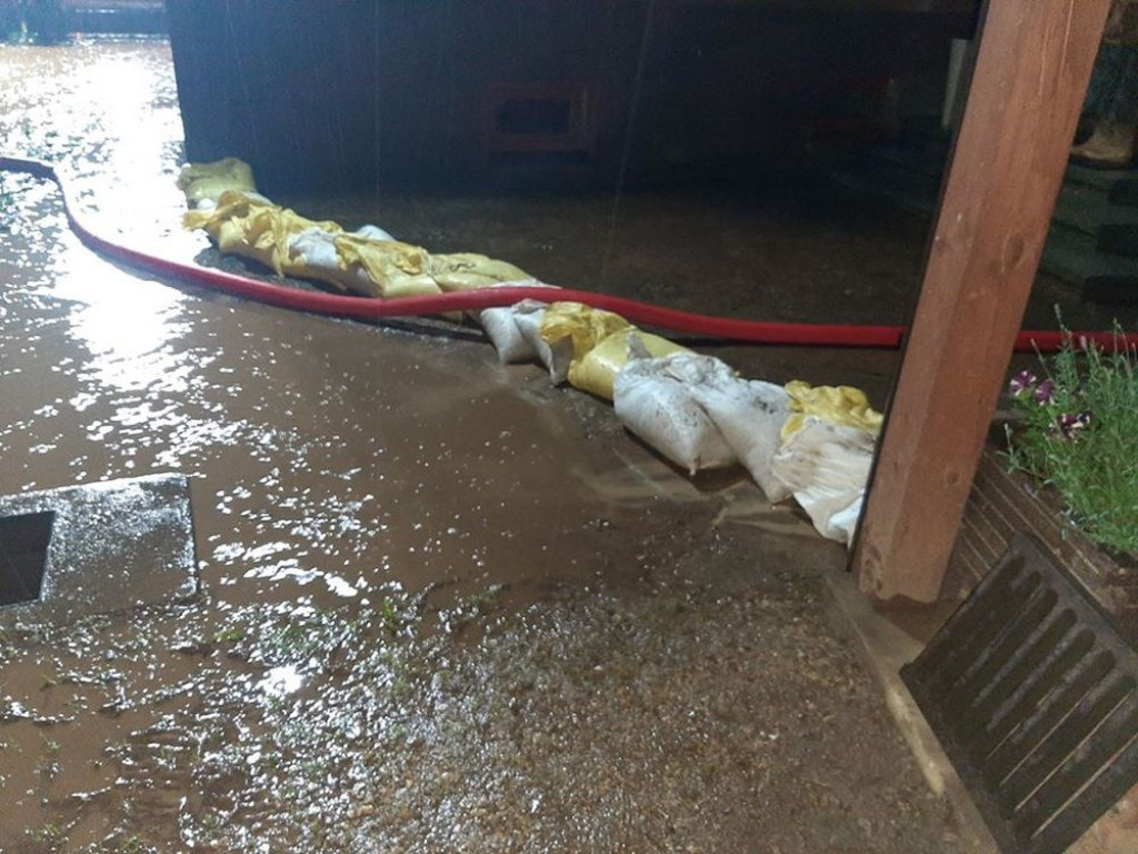 Zalane posesje, powalone drzewa, wyrwa w drodze