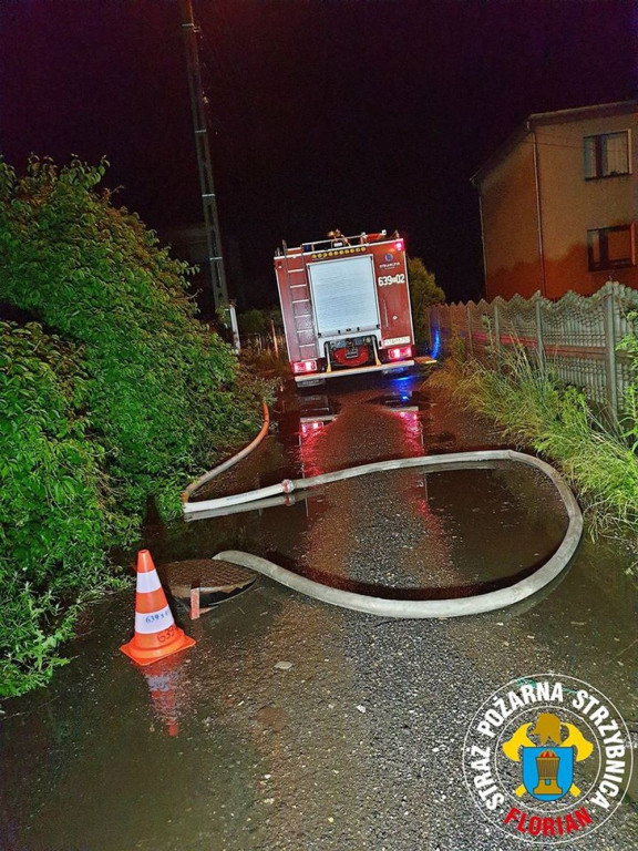 Zalane posesje, powalone drzewa, wyrwa w drodze