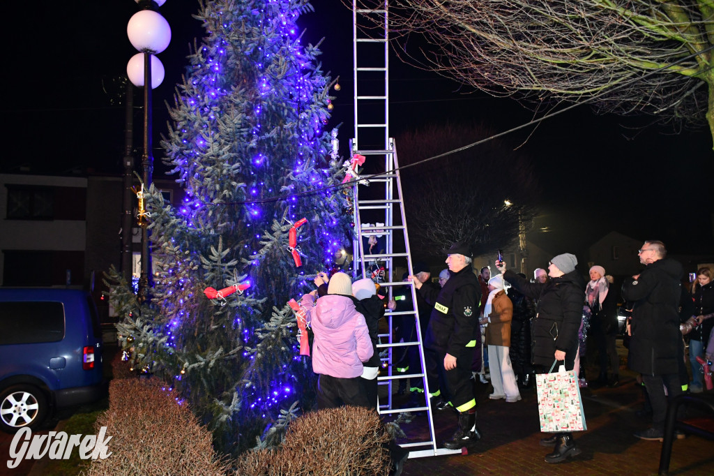 Dzieci i Mikołaj na drabinie. Strojenie choinki