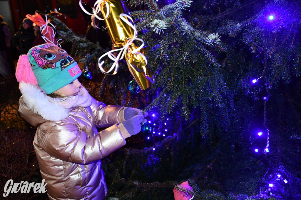 Dzieci i Mikołaj na drabinie. Strojenie choinki