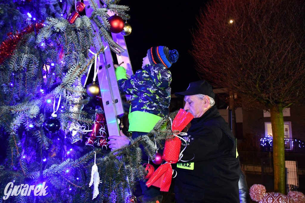 Dzieci i Mikołaj na drabinie. Strojenie choinki