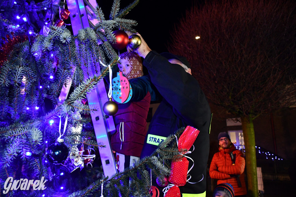 Dzieci i Mikołaj na drabinie. Strojenie choinki
