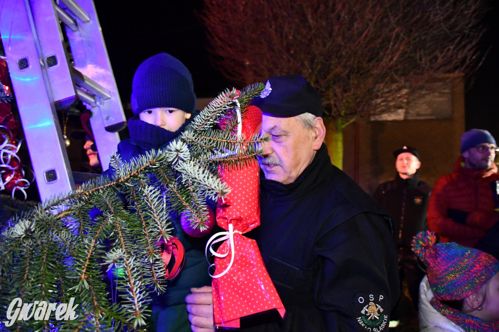 Dzieci i Mikołaj na drabinie. Strojenie choinki