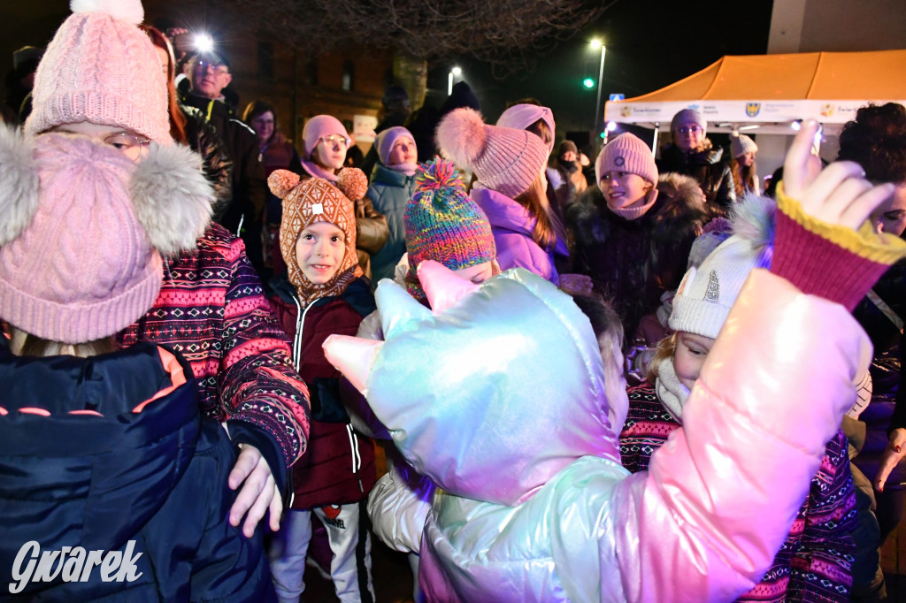 Dzieci i Mikołaj na drabinie. Strojenie choinki