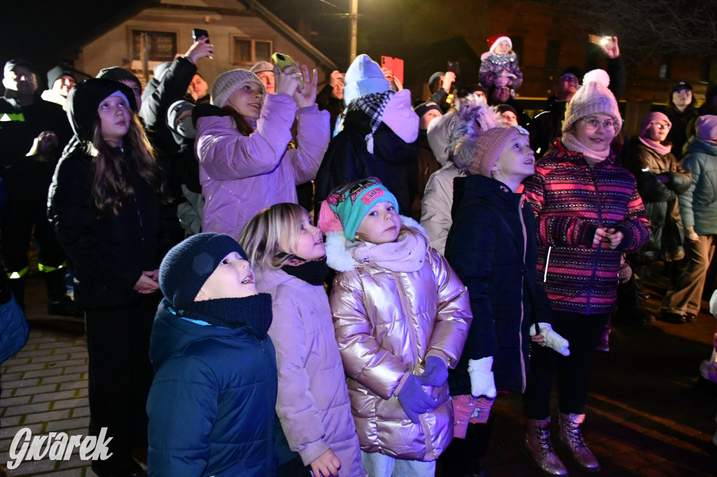 Dzieci i Mikołaj na drabinie. Strojenie choinki