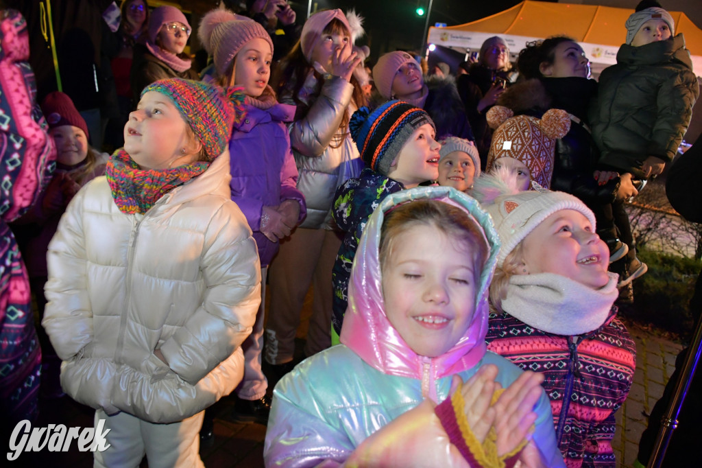 Dzieci i Mikołaj na drabinie. Strojenie choinki