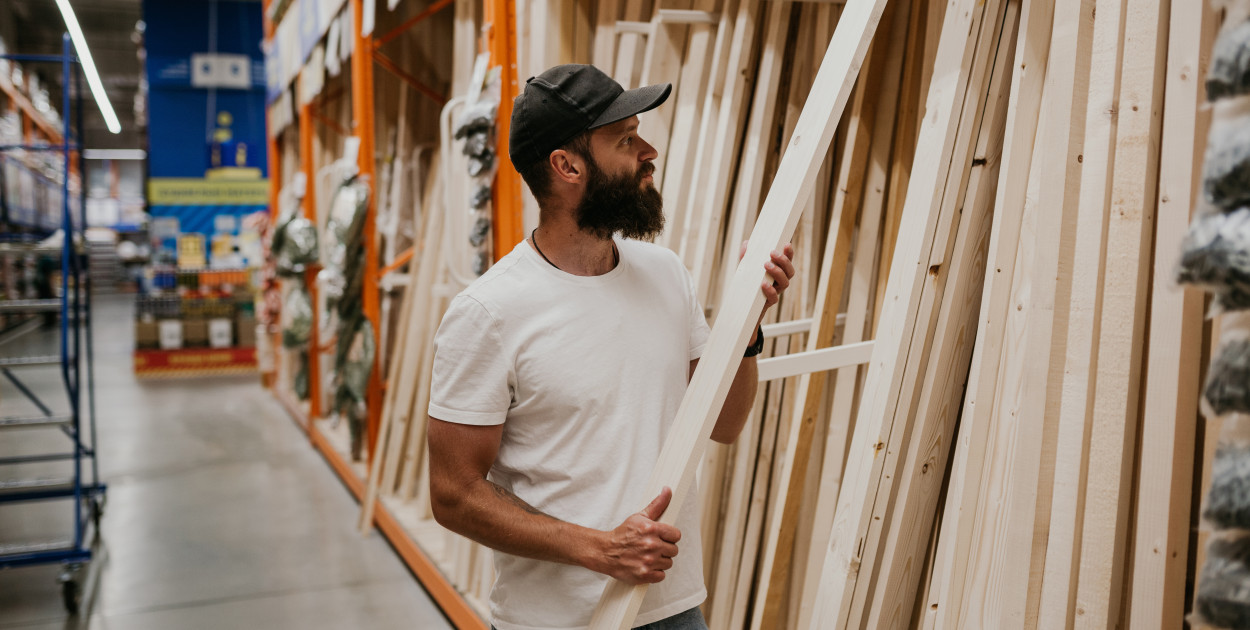 Mężczyzna wybiera drewno w sklepie budowlanym OBI na strzelców. Fot. Adobe Stock
