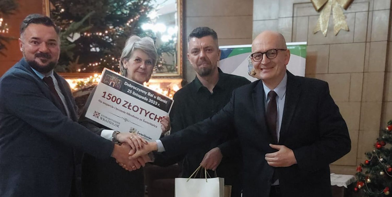 Pieniądze dla Nikodema zbierano też podczas balu w Pałacu Kawalera. Symboliczny czek ojcu chłopca przekazali członkowie stowarzyszenia Wrazidlok i wójt Marek Cyl. Fot. Archiwum stowarzyszenia Wrazidlok