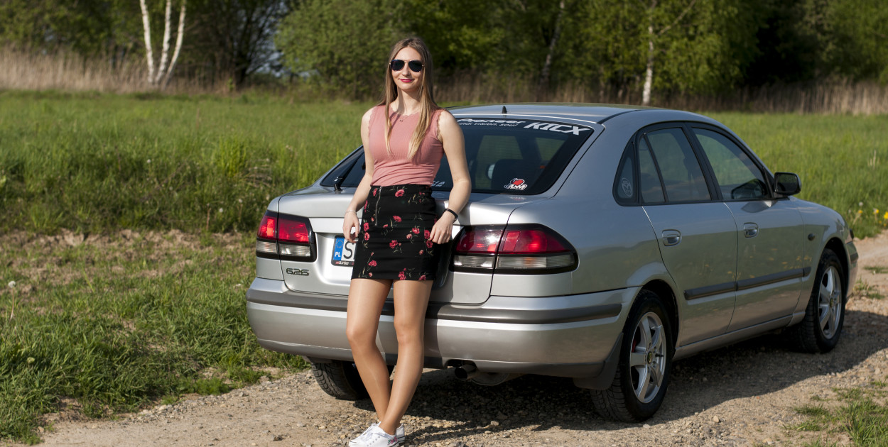 Wioletta Cebulska przy samochodzie marki Mazda 626 z 1998 roku